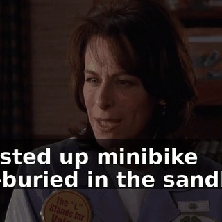 a busted up minibike half-buried in the sandbox?