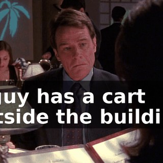 A guy has a cart outside the building.